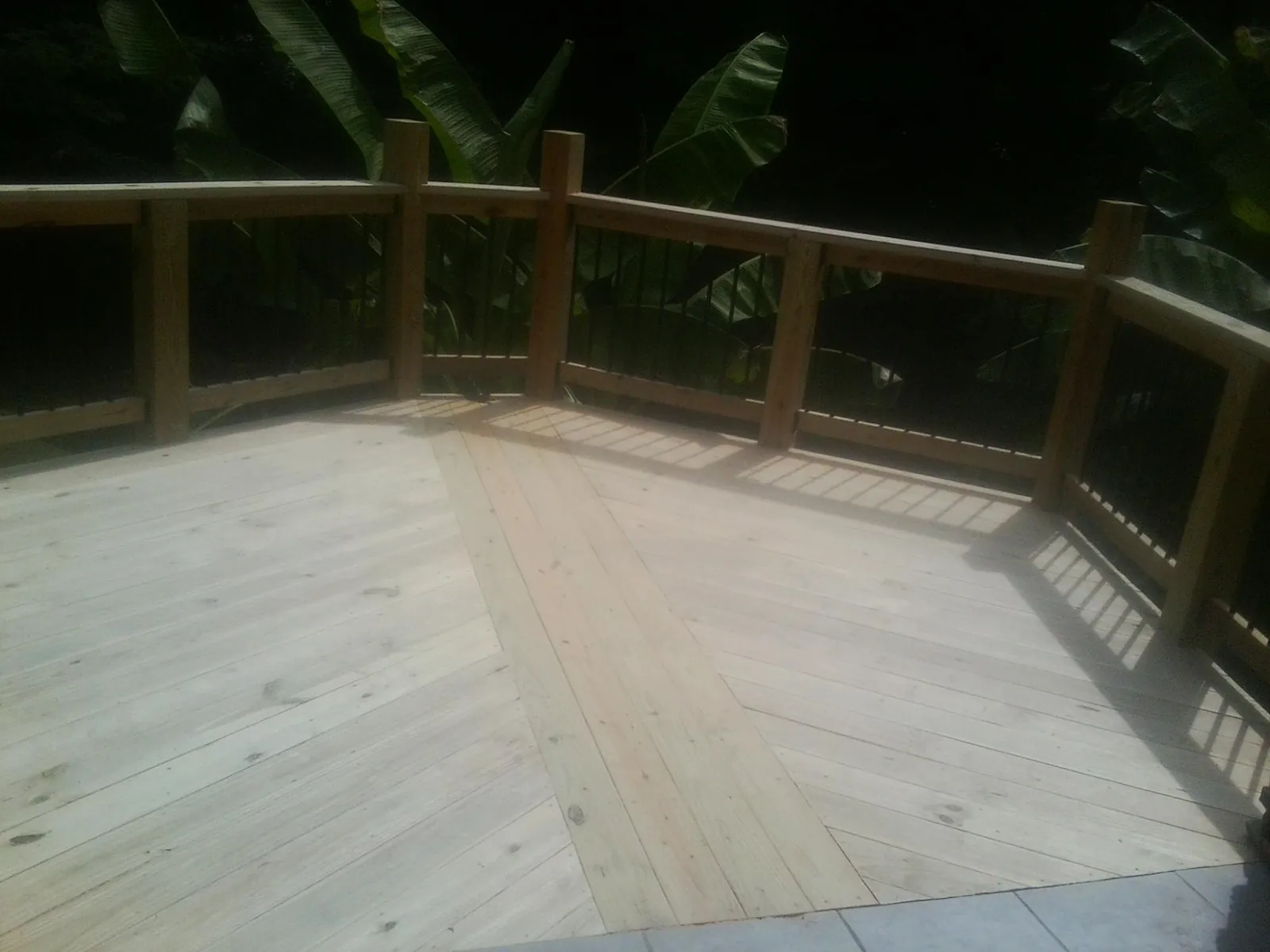 New wood deck and railing built off the back of a home in Camden